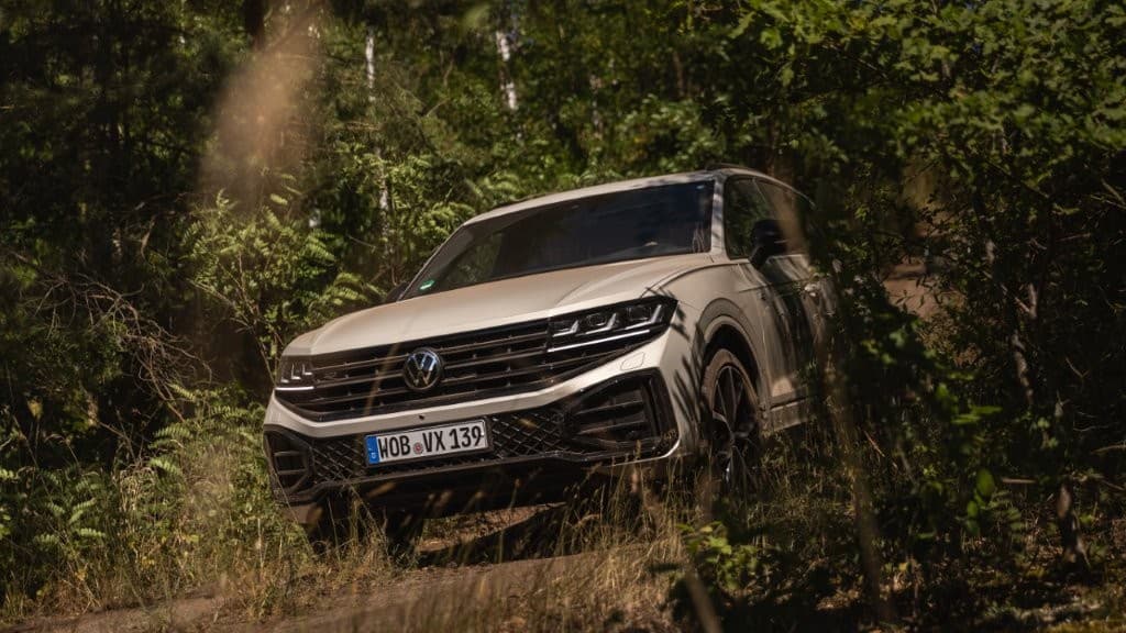SUV auf unbefestigtem Weg beim Geländetraining im Waldstück